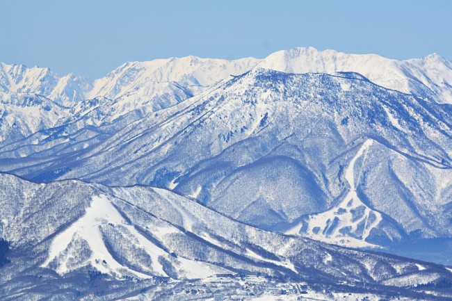 Madarao and unknown resort in the distance we can see the towering Hakuba range over 65km away