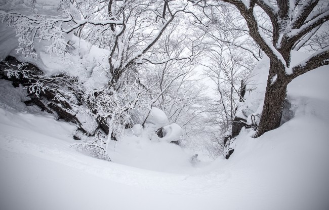 Kelsey slides through a narrow rocky chute somewhere in Nozawa Onsen.