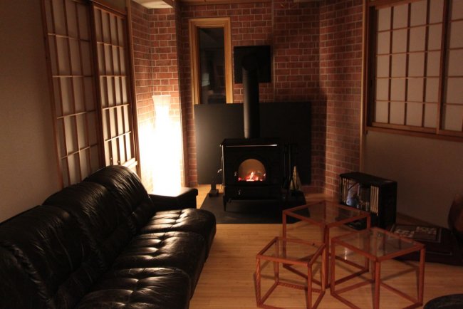 Cosy communal areas with a warming fireplace at Lodge Nagano 