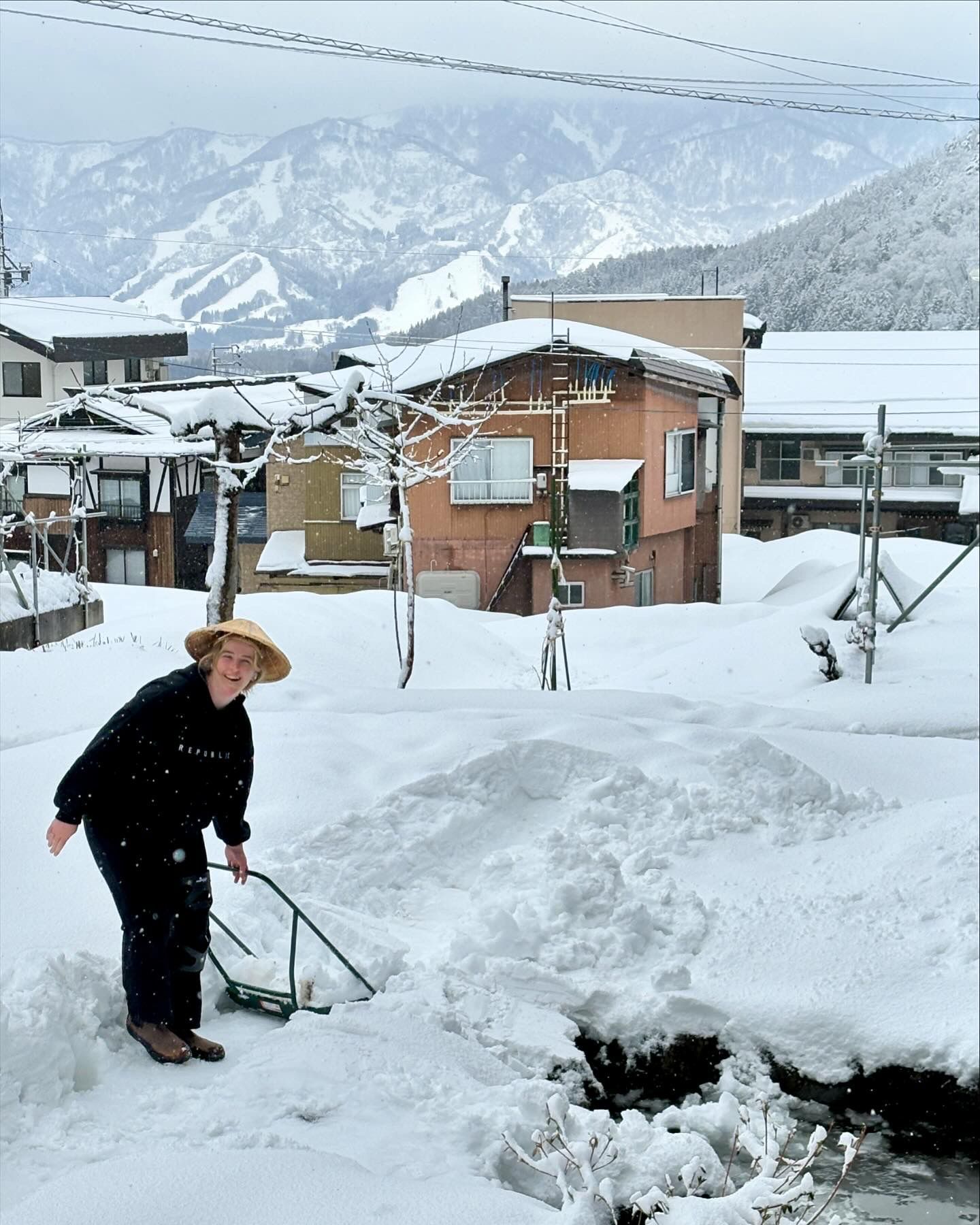 The staff of Nozawa Onsen taking care of the snow outside of the lodge