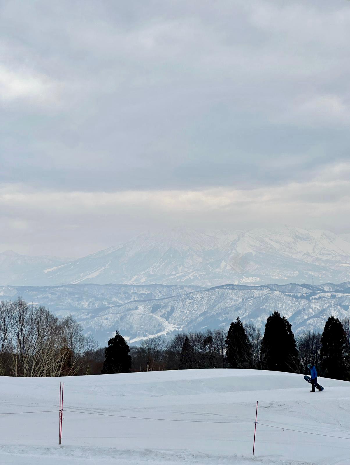 snowboarder walking back up to the top of the halfpipe 