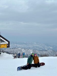 skiiers learning to snowboard at the top of yamibiko