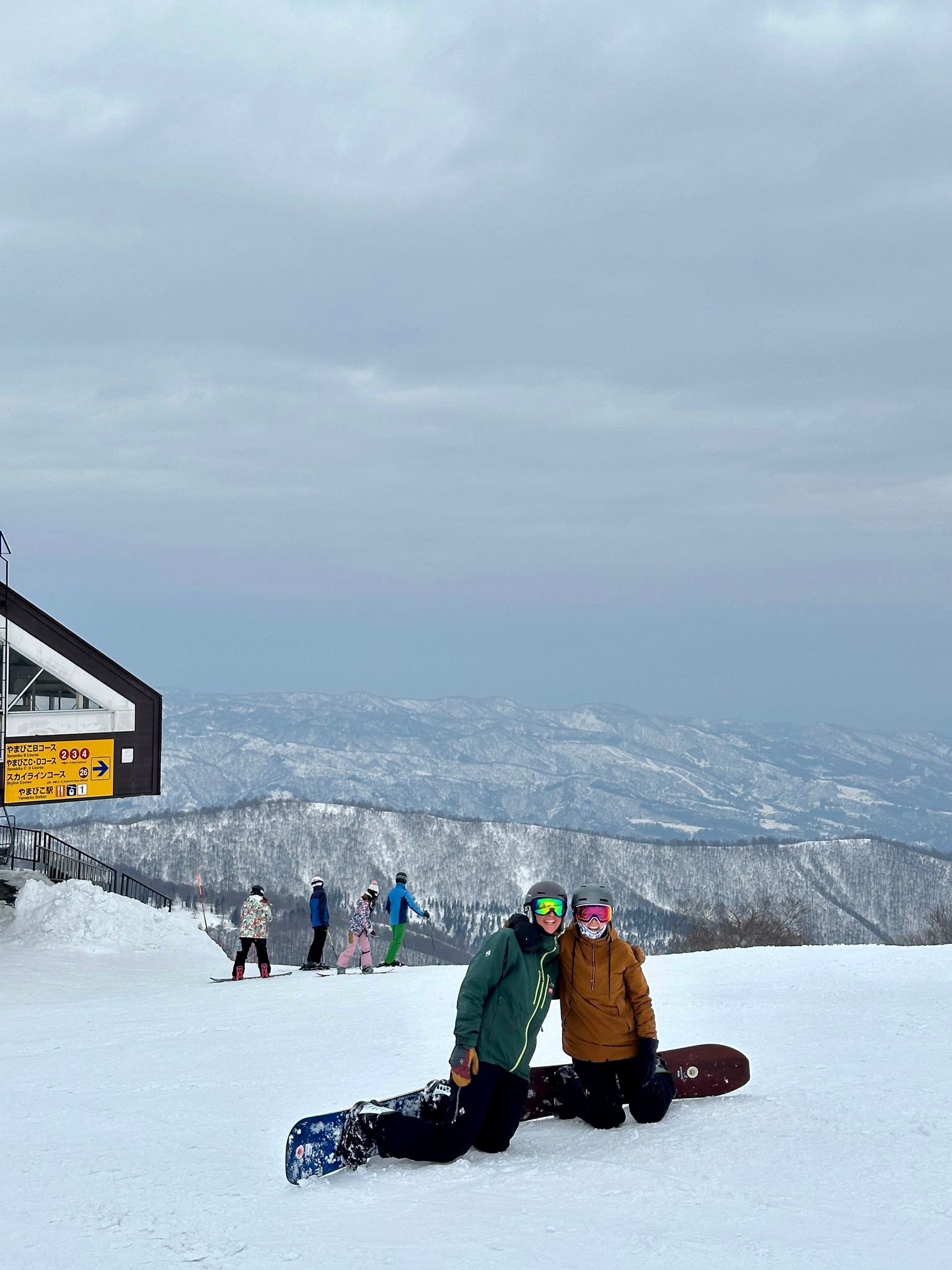 skiiers learning to snowboard at the top of yamibiko 