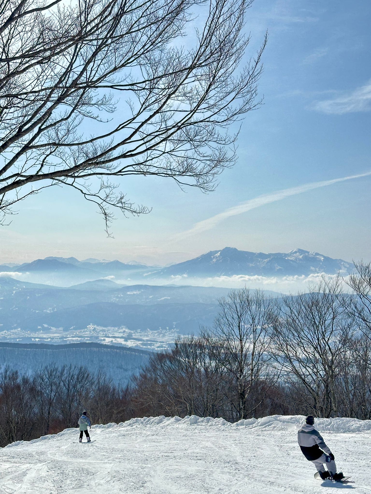 snowboarder riding down skyline sunny